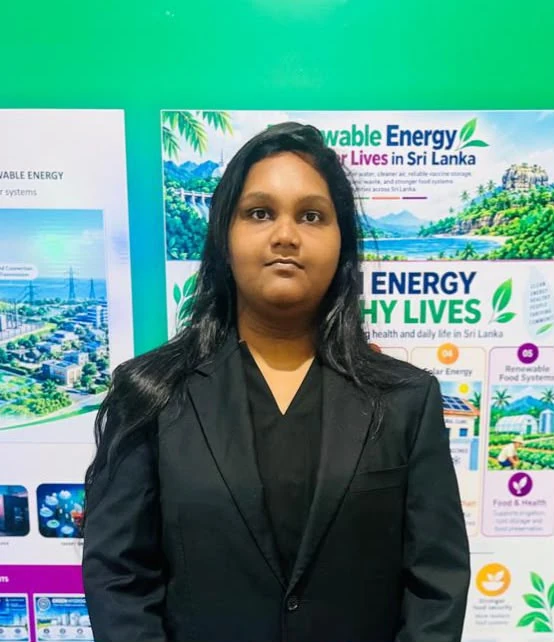 A club member in a black blazer beside the sustainable energy billboard
